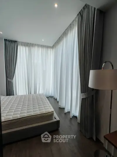 Spacious bedroom with floor-to-ceiling windows and elegant curtains