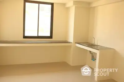 Minimalist kitchen space with large window and sleek countertop