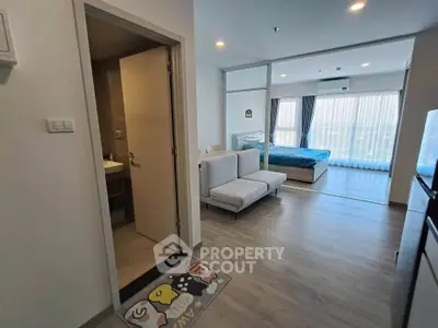 Modern open-plan apartment with spacious bedroom and living area, featuring large windows for natural light.