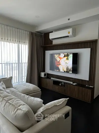 Modern living room with cozy sofa, large TV, and stylish decor