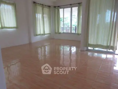 Spacious sunlit room with large windows and tiled flooring, ideal for versatile living space.