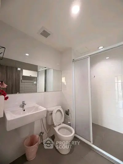 Modern bathroom with sleek design, featuring a shower and contemporary fixtures.