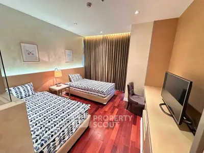 Spacious bedroom with twin beds and modern decor, perfect for comfortable living.
