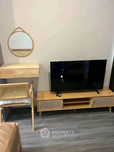 Modern living room with stylish wooden furniture and flat-screen TV, perfect for cozy relaxation.