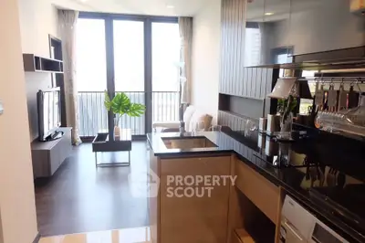 Modern open-plan living room and kitchen with sleek design and large windows