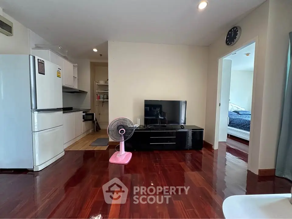 Modern apartment living room with sleek hardwood floors and open kitchen layout