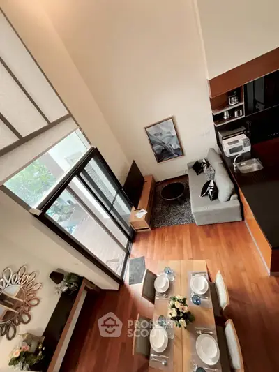 Stunning open-plan living room with modern decor and balcony access, perfect for entertaining.