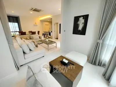 Modern living room with elegant decor and open layout, featuring cozy seating and stylish artwork.