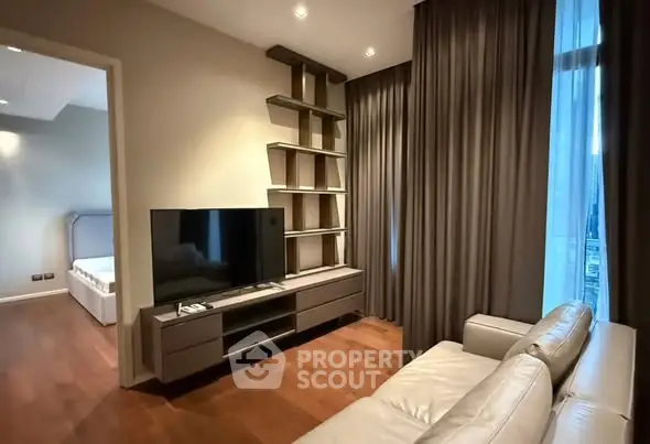 Modern living room with sleek TV unit and cozy sofa, adjacent to a stylish bedroom.