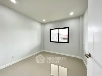 Spacious empty room with large window and glossy tiled floor