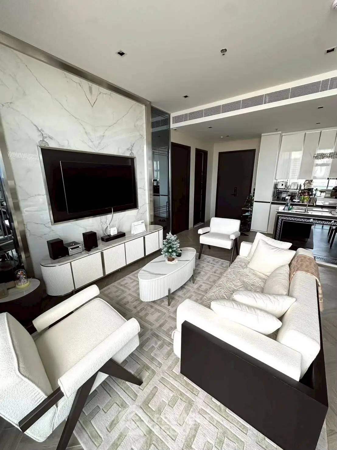 Luxurious modern living room with elegant furniture and open kitchen layout, perfect for stylish urban living.