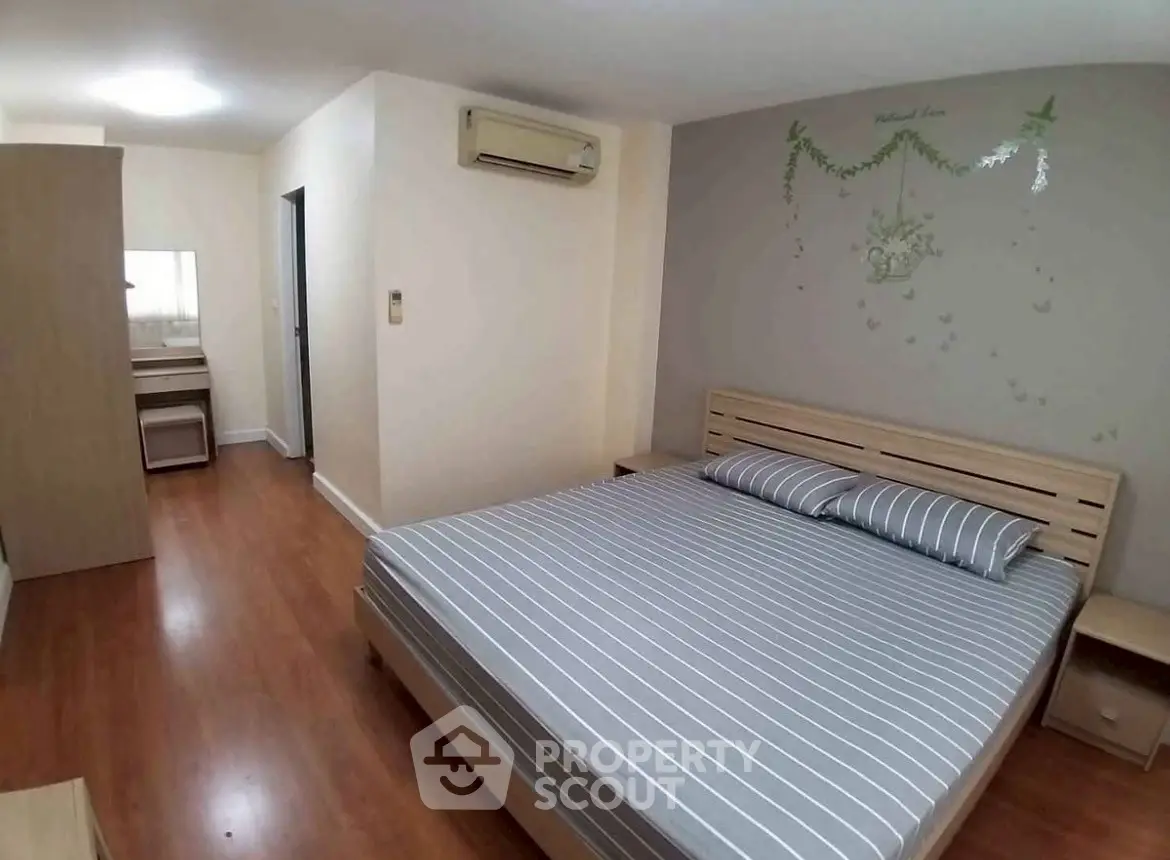 Spacious bedroom with modern decor and wooden flooring