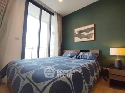 Modern bedroom with stylish decor and large window offering natural light.