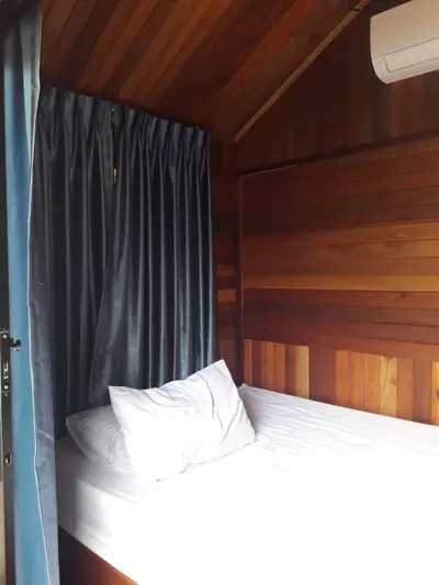 Cozy wooden bedroom with air conditioning and elegant curtains