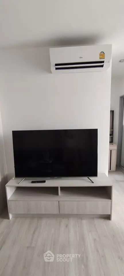 Modern living room with sleek TV setup and air conditioning unit, perfect for comfortable living.