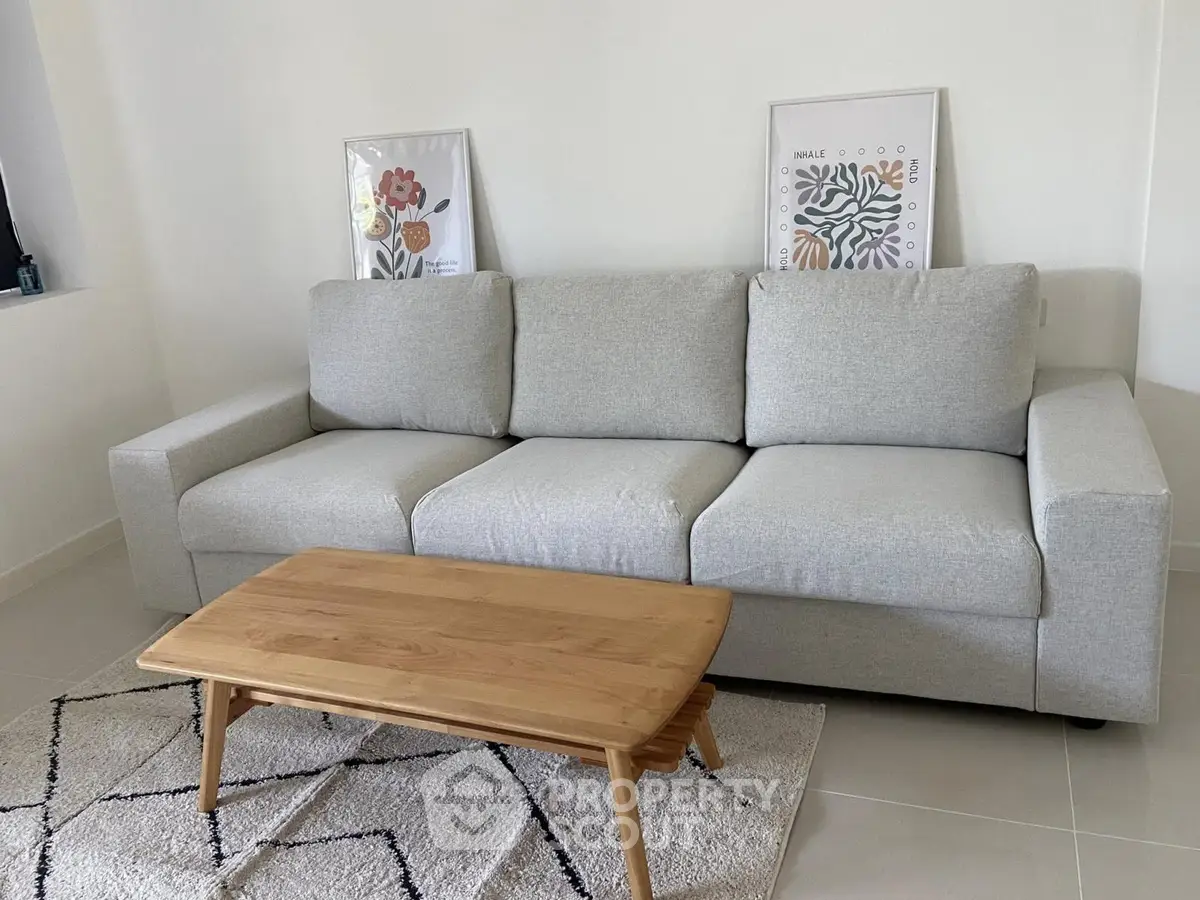 Modern living room with stylish gray sofa and wooden coffee table on a chic rug.