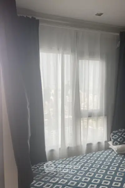 Cozy bedroom with large window and stylish patterned bedding
