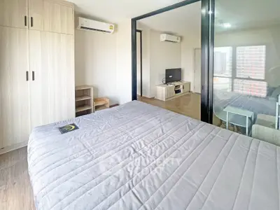Modern bedroom with wooden furniture and large window offering city view