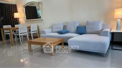 Spacious living room with modern gray sofa and elegant dining area