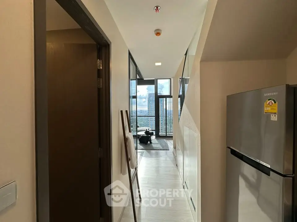 Modern apartment hallway leading to a bright living room with a stunning view.