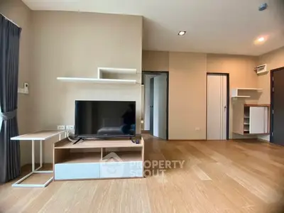 Spacious modern living room with wooden flooring and sleek TV setup