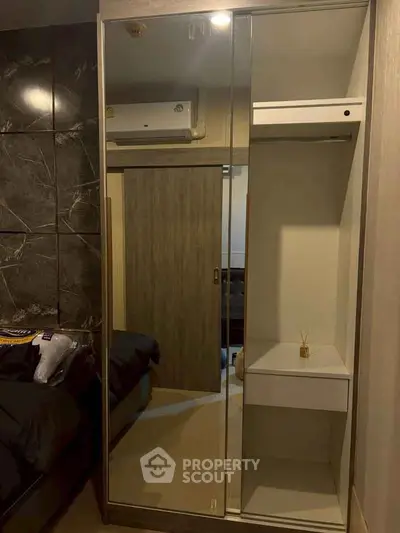 Modern bedroom with mirrored wardrobe and air conditioning unit