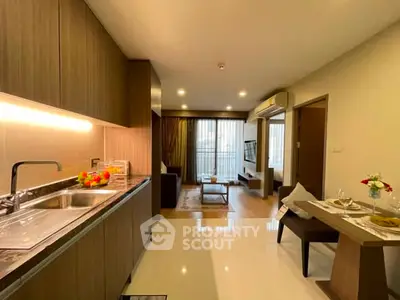 Modern open-layout kitchen and living room with sleek design and natural light.