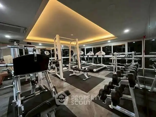 Modern gym with state-of-the-art equipment and ambient lighting in luxury residential building.