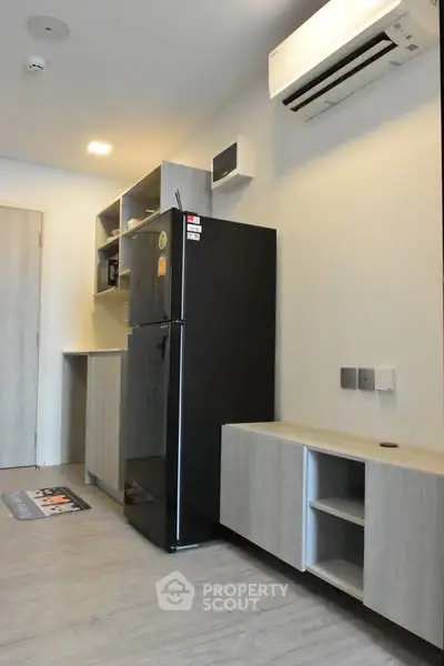 Modern kitchen with sleek black fridge and air conditioning unit