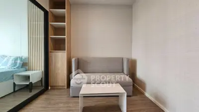 Modern minimalist living room with cozy sofa and sleek coffee table, adjacent to a stylish bedroom.