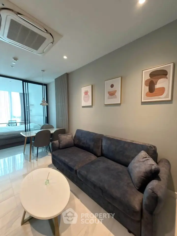 Modern living room with stylish decor and open layout, featuring a cozy sofa and elegant dining area.