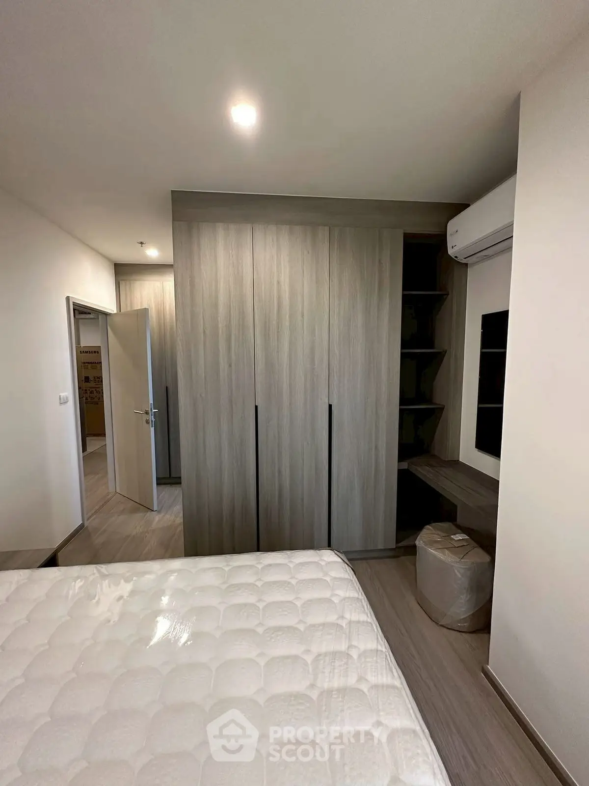 Modern bedroom with built-in wardrobe and air conditioning unit