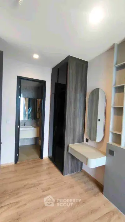 Modern bedroom with sleek design, featuring a built-in wardrobe and stylish vanity area.