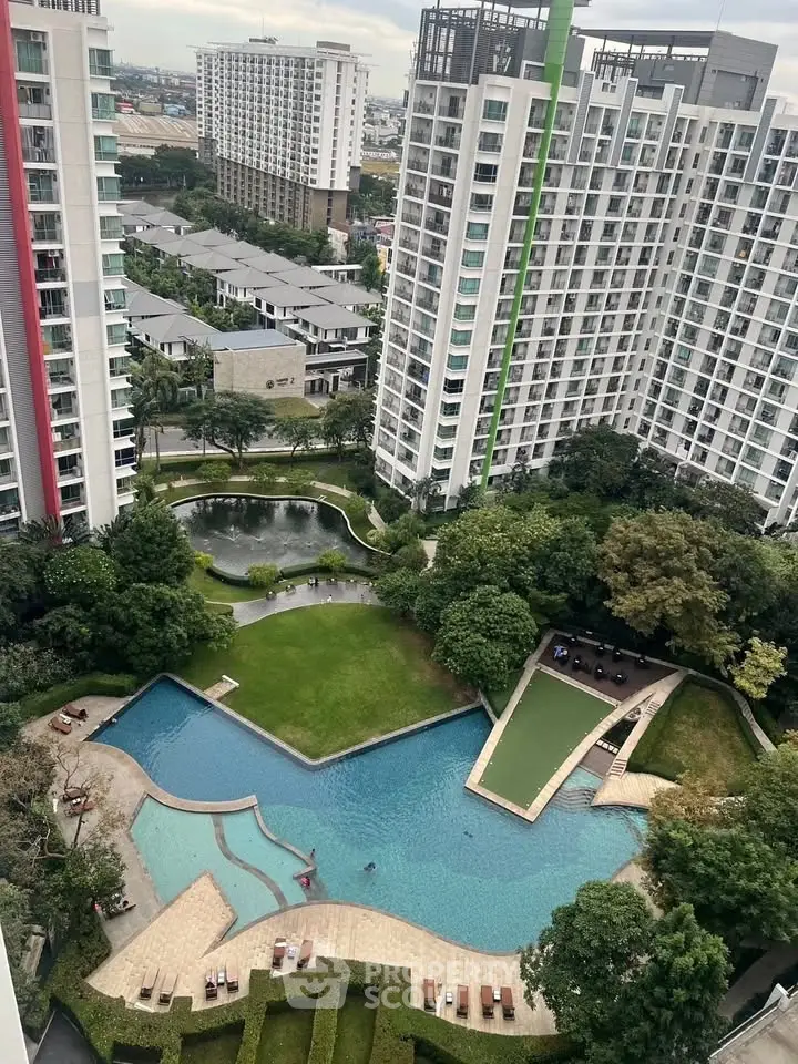 Stunning aerial view of modern apartment complex with lush gardens and inviting swimming pool.