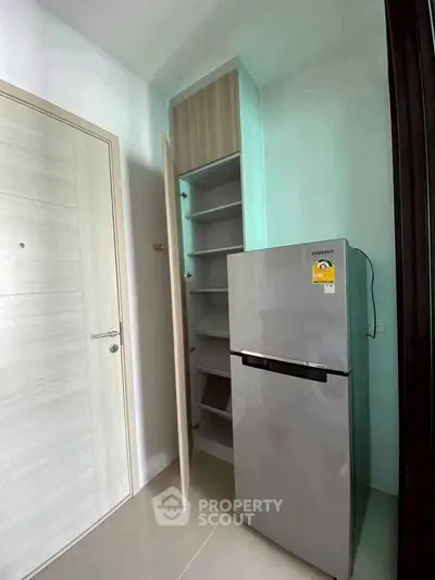 Modern kitchen corner with sleek fridge and built-in storage shelves