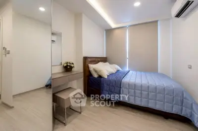 Modern bedroom with sleek design, featuring a cozy bed, stylish mirror, and elegant decor in a bright setting.