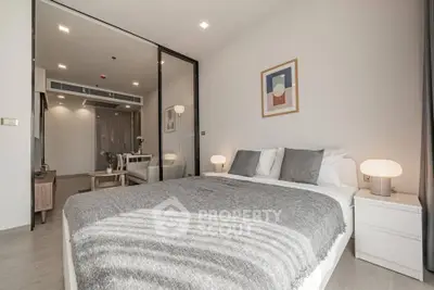 Modern bedroom with cozy decor and stylish lighting in a contemporary apartment.