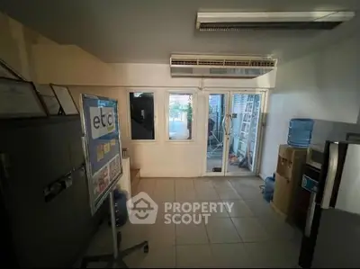 Spacious office room with large windows and modern air conditioning unit.