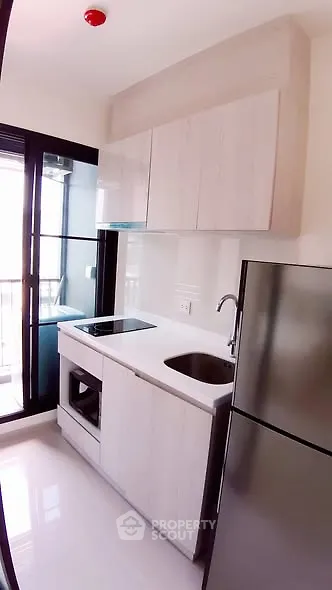 Modern kitchen with sleek cabinetry and stainless steel appliances in a bright apartment.