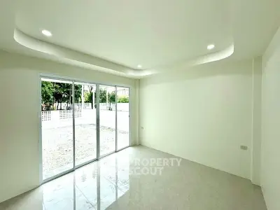 Spacious unfurnished room with large sliding glass doors and recessed lighting.