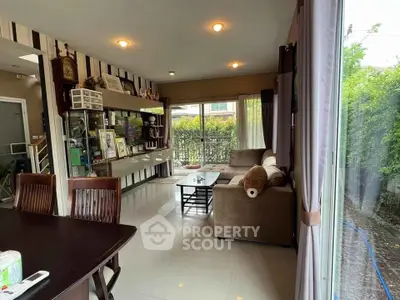Spacious living room with modern decor and large windows overlooking a lush garden.