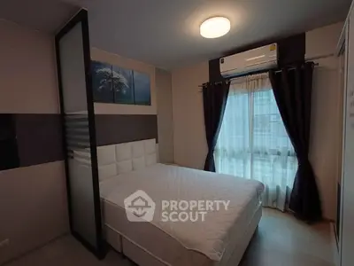 Modern bedroom with stylish decor and natural light, featuring a comfortable bed and air conditioning.