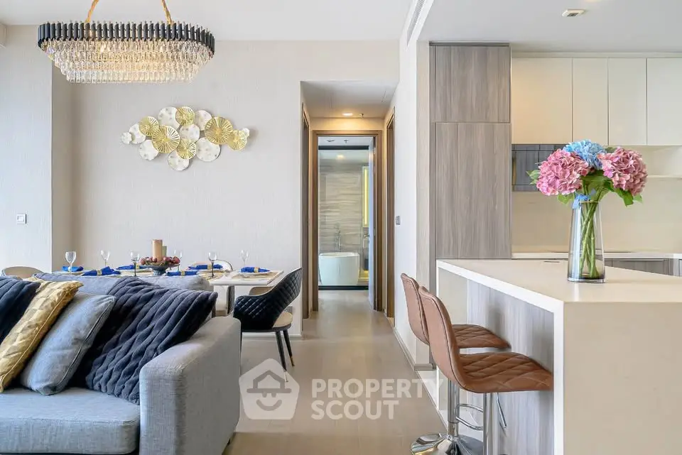 Luxurious open-plan living room with elegant dining area and modern kitchen, featuring chic decor and a cozy ambiance.