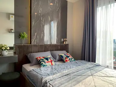 Luxurious bedroom with modern decor and large window offering natural light.