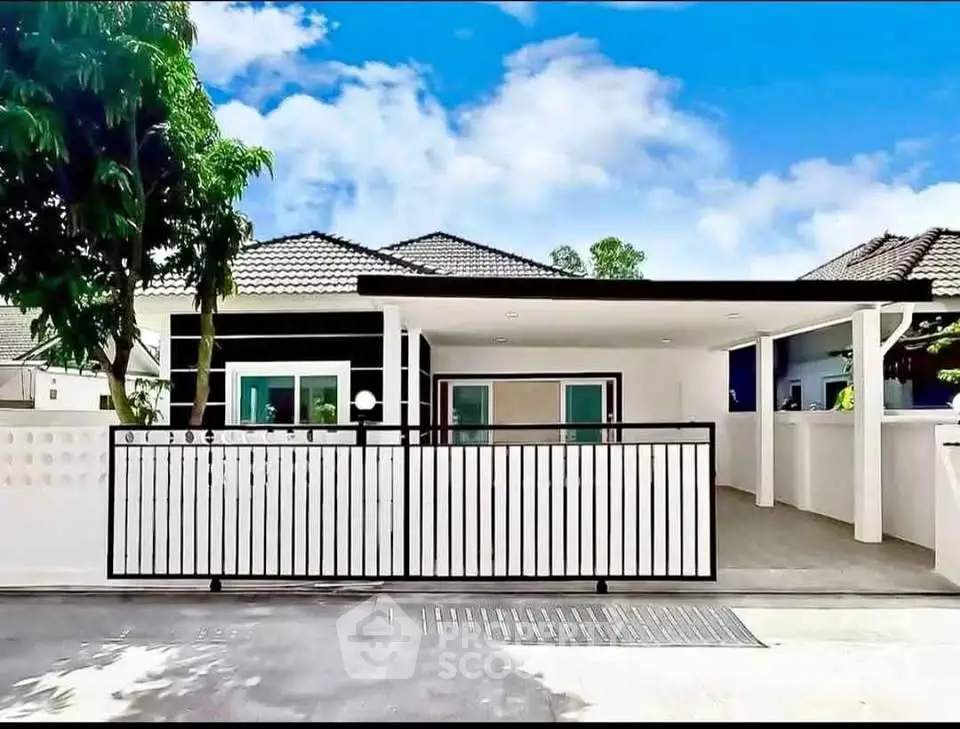 Modern single-story house with gated entrance and carport in a serene neighborhood.