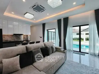 Luxurious living room with pool view, modern decor, and elegant lighting in a contemporary home.