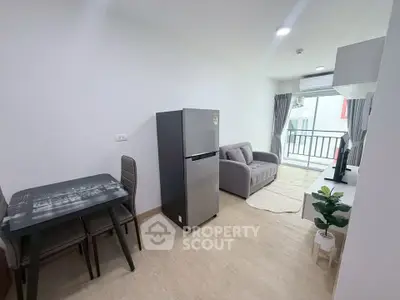 Modern living room with balcony, featuring sleek furniture and natural light.