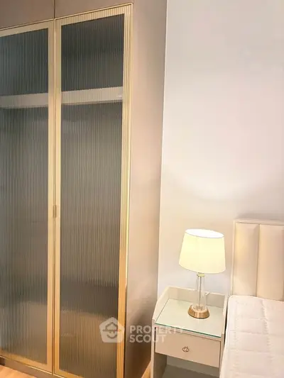 Elegant bedroom with stylish wardrobe and bedside lamp, perfect for modern living.