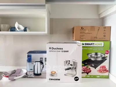 Modern kitchen with appliances including espresso machine and induction cooker, showcasing sleek design and functionality.