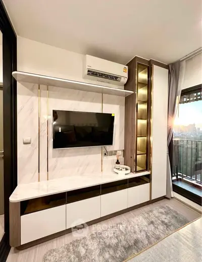 Modern living room with sleek TV unit and balcony view, featuring stylish storage and air conditioning.